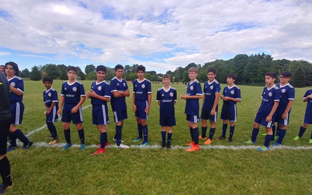 A kids soccer team decked out in BlueCat jerseys