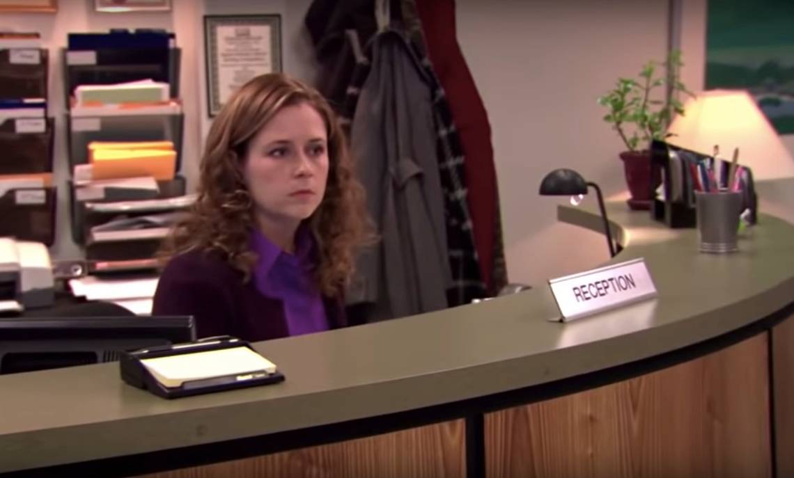 Office receptionist sitting at a front desk, looking frustrated, symbolizing admins stuck managing IPAM with basic DNS tools