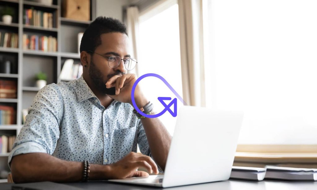 Seated man looks at laptop