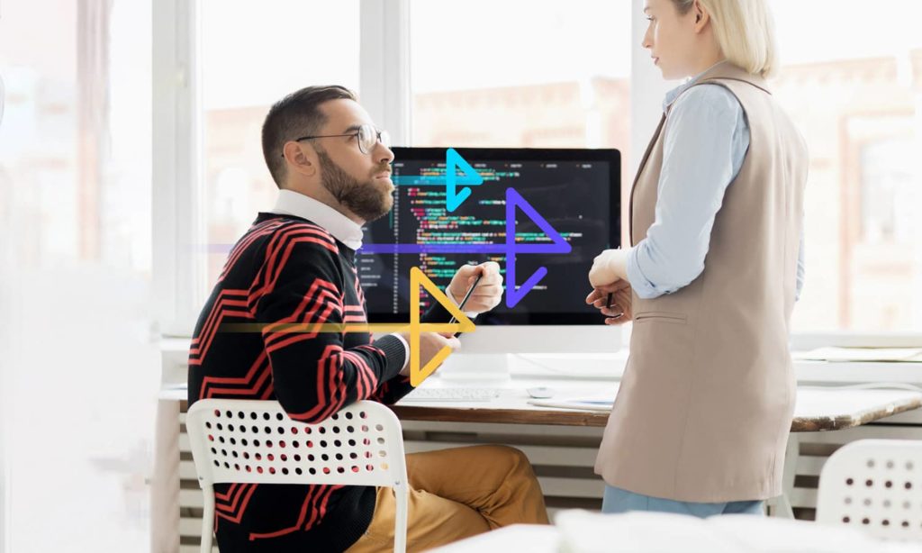 Two people have a conversation in front of a screen