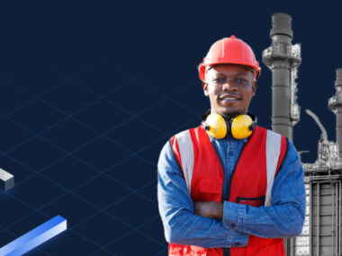 A man in a hard hat and safety vest stands before an oil refinery. BlueCat offers Intelligent NetOps solutions, including Unified DDI, for the energy industry.